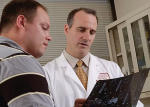 Doctor in a white coat reviewing a document with a patient